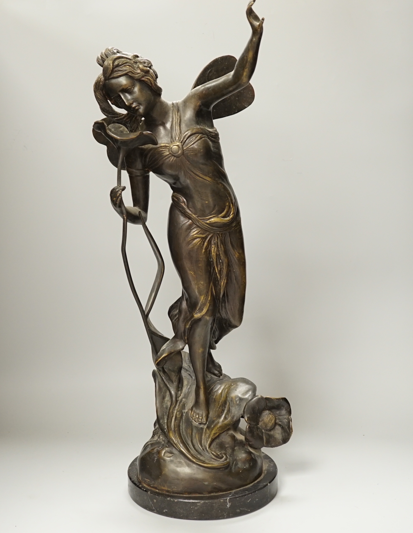 An Art Nouveau style fairy on a black marble base, 63.5cm high